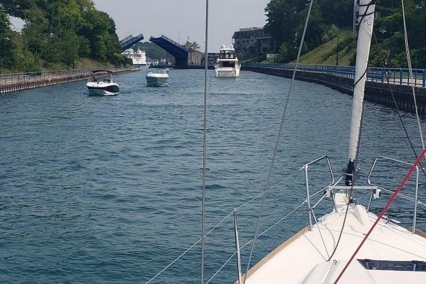 Un velero en un río, con un puente al fondo. 2