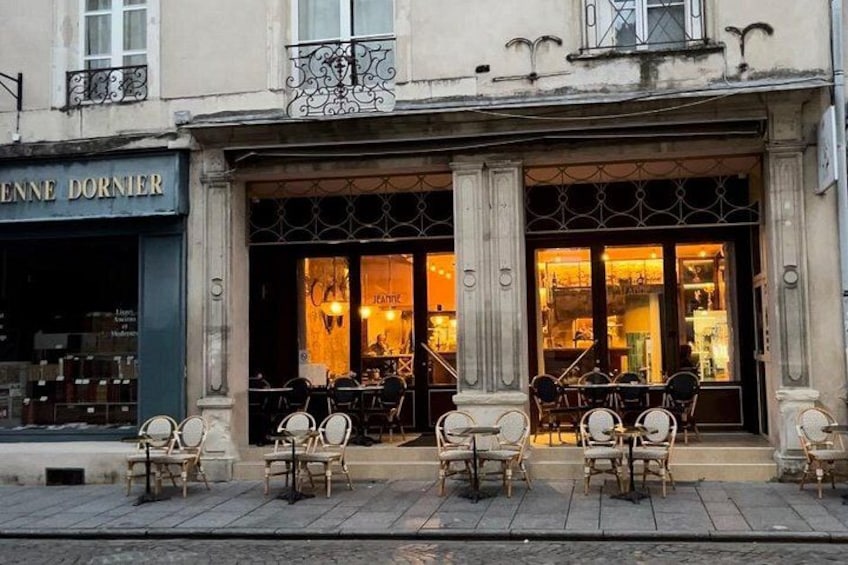 A cafe with outdoor seating, a storefront with large windows, and a sign that reads 'ENNE DORNIER'. 5