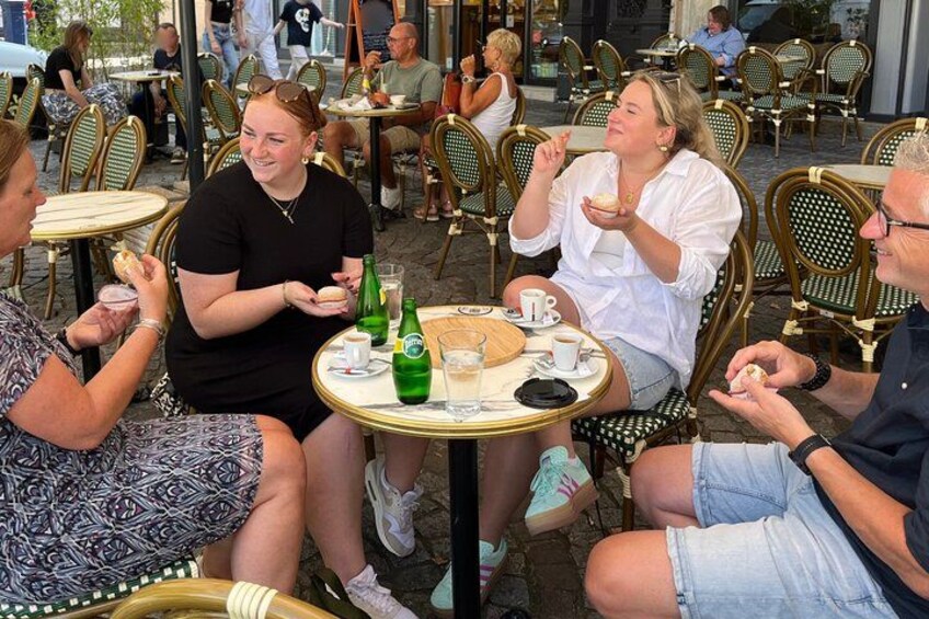 People sitting at outdoor tables, eating and drinking. 5