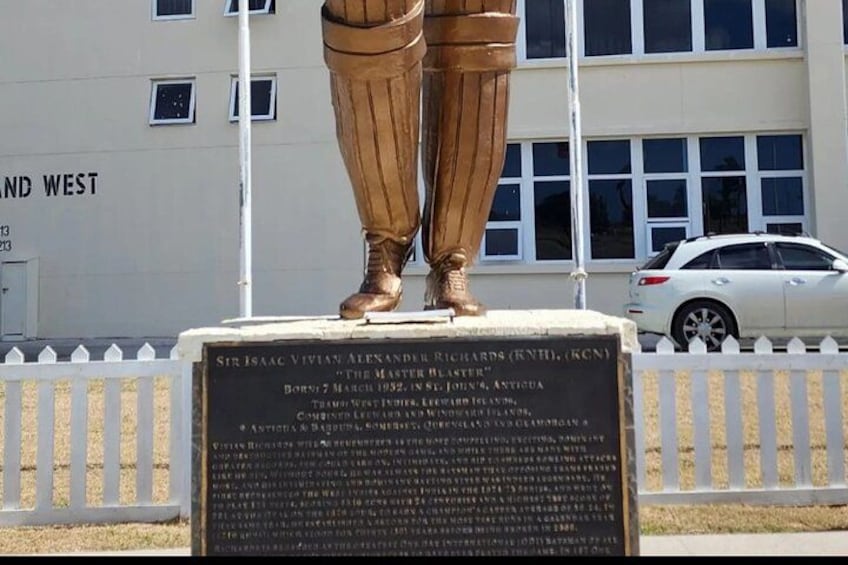 Een standbeeld van een man in pak en das, met een plaquette voor een gebouw. 3