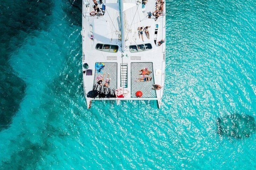 Un barco con gente en cubierta, rodeado de agua turquesa. 1