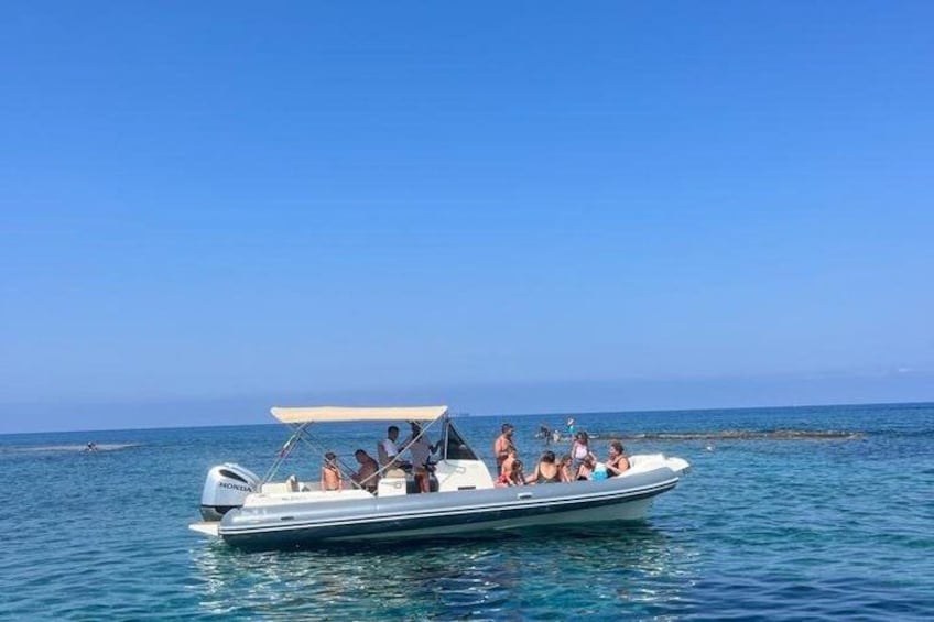 A boat with people on a calm sea under a clear sky. 1