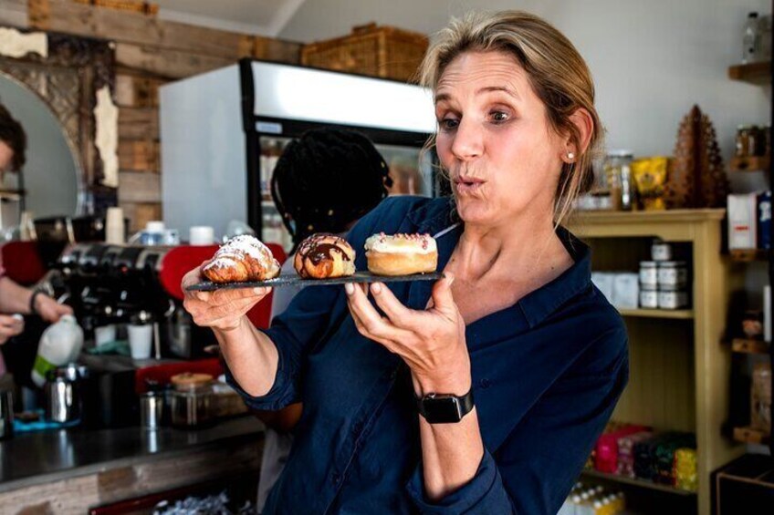 Iemand houdt twee gebakjes vast in een keuken. 1