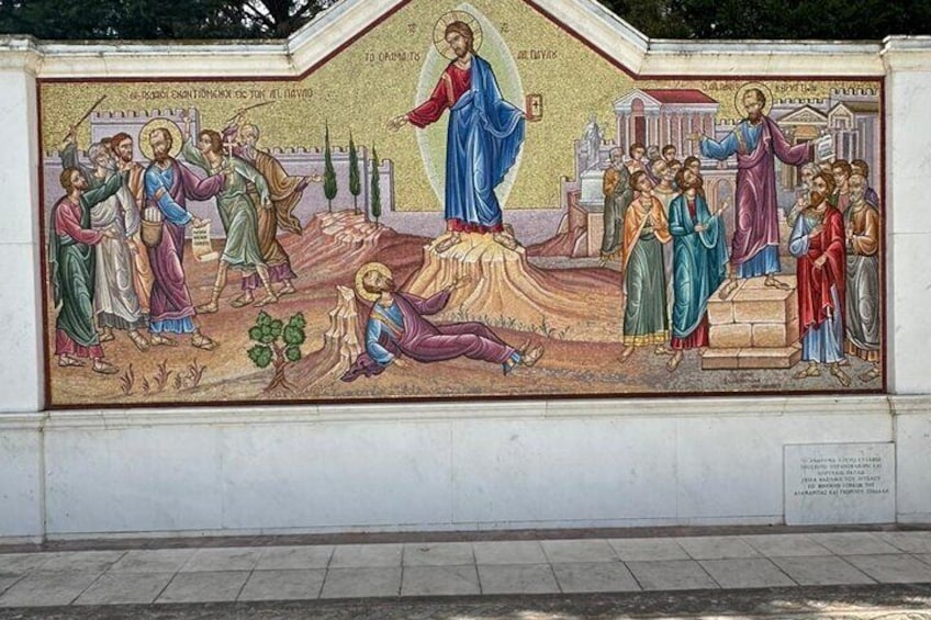 A mural with religious figures and a central figure on a hill, surrounded by people. 5