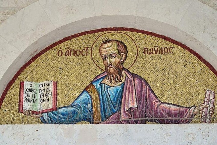 Une mosaïque représentant une figure tenant un livre et une croix, entourée d’un halo et de texte en grec. 2