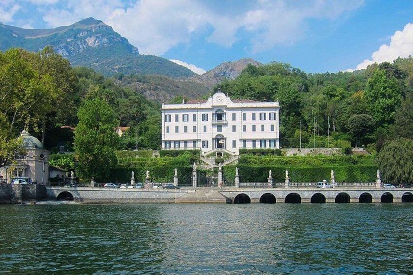 A white building with a dome, a bridge with arches, and a mountain in the background. 2