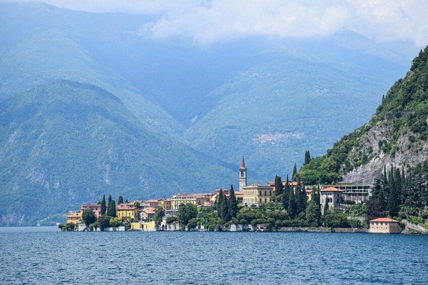 A coastal town with buildings, a church, and mountains in the background. 4