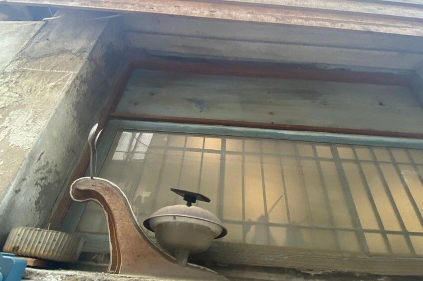A window with bars, a metal object, and a rusty metal part. 2