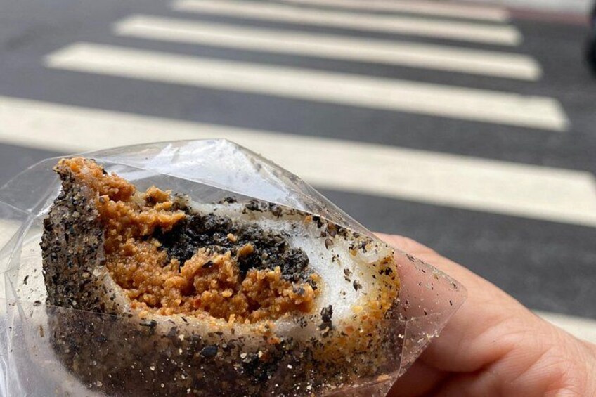 A hand holding a partially eaten snack with a clear plastic wrapper. 3