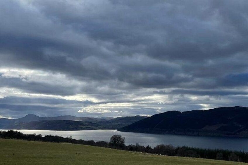 A lake surrounded by mountains under a cloudy sky. 3