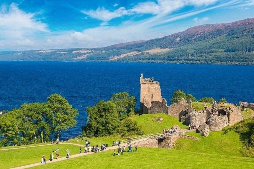 A historic castle ruin by a lake with a clear sky. 2
