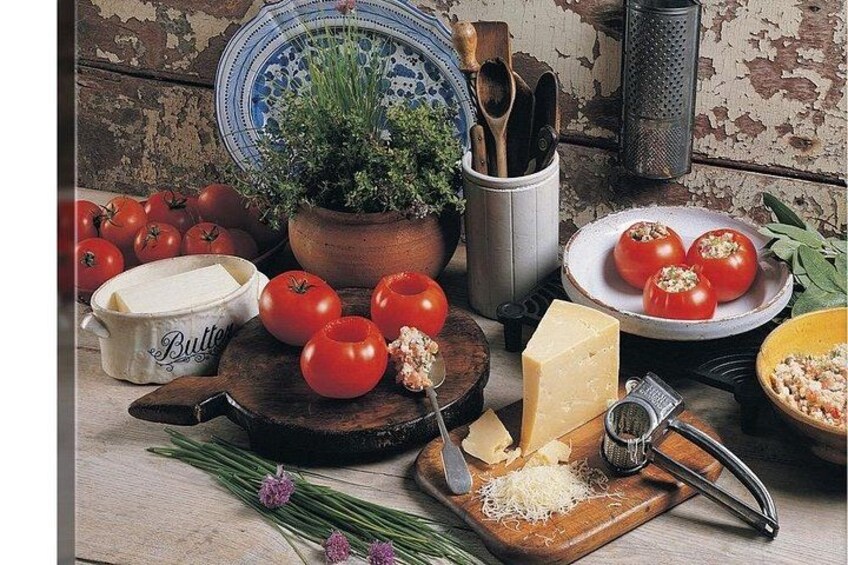 Een keuken met tomaten, kaas, een rasp en een snijplank. 1