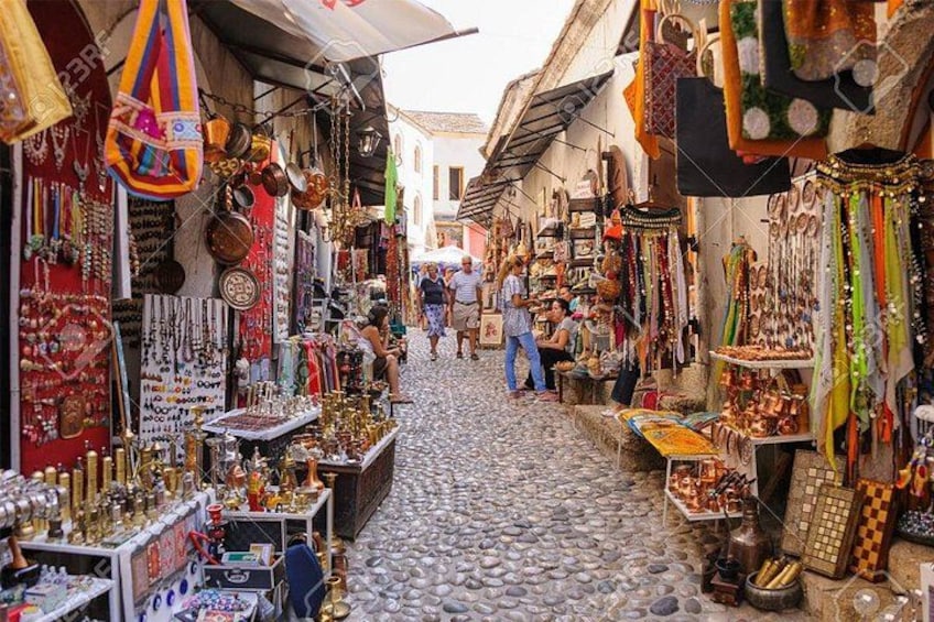 Una estrecha calle empedrada flanqueada por diversas tiendas que venden joyería y baratijas. 4