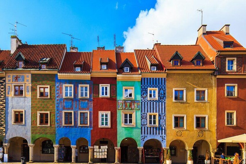 A row of colorful buildings with distinct architectural styles and a clear blue sky. 1