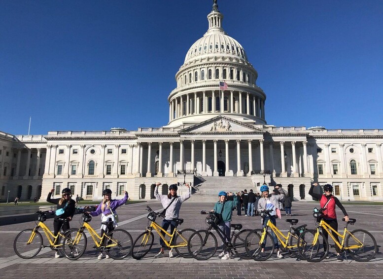 Un grupo de personas con bicicletas frente a un gran edificio gubernamental con una cúpula. 3