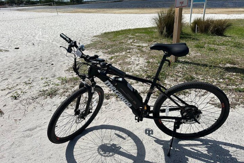 Electric Mountain Bike parked right next to the sandy beach. 2