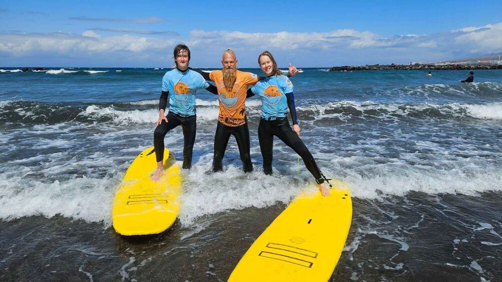 Three people on surfboards in the ocean with waves. 5