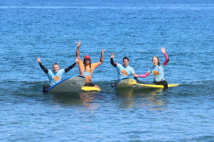 Four people on surfboards in the water. 4