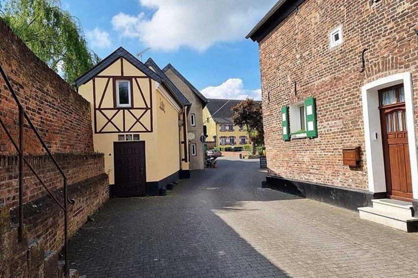 Eine enge Kopfsteinpflasterstraße, gesäumt von traditionellen Fachwerkhäusern. 2