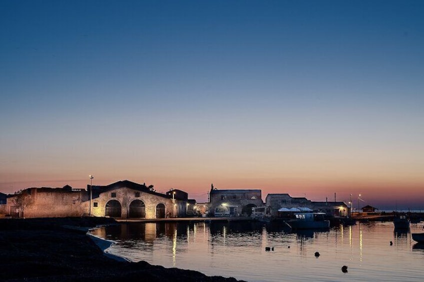 Une vue sur le bord de l’eau au crépuscule, avec un pont, des bâtiments et des bateaux. 2