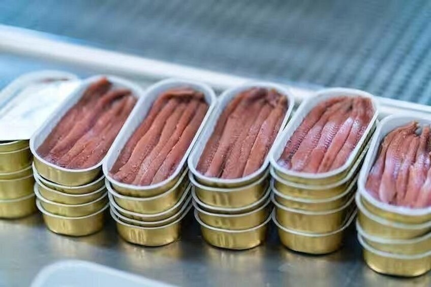 Several metal containers with fish fillets. 1
