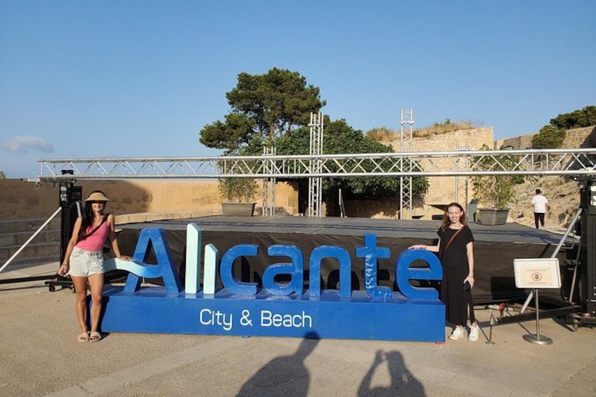 Un letrero con la palabra 'Alicante' y la frase 'Ciudad y Playa' sobre un fondo azul. 1