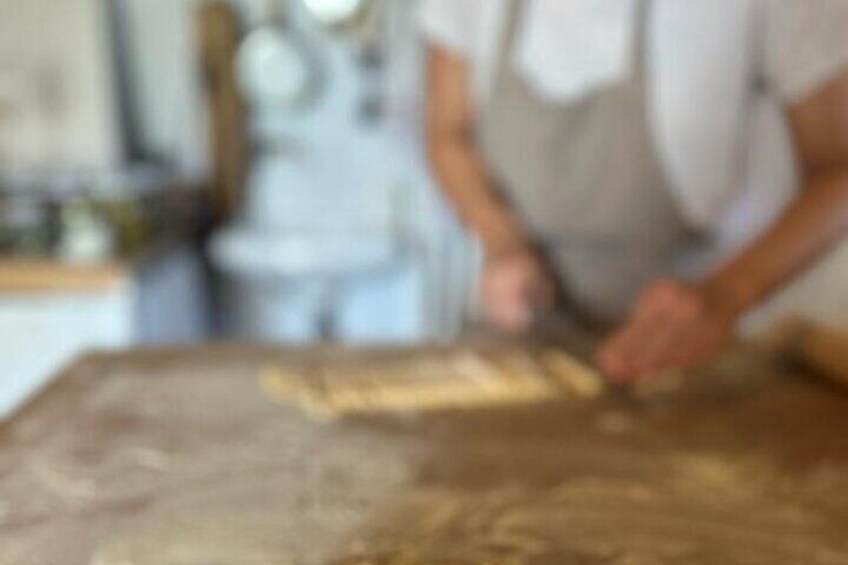 A person working with dough on a table. 1