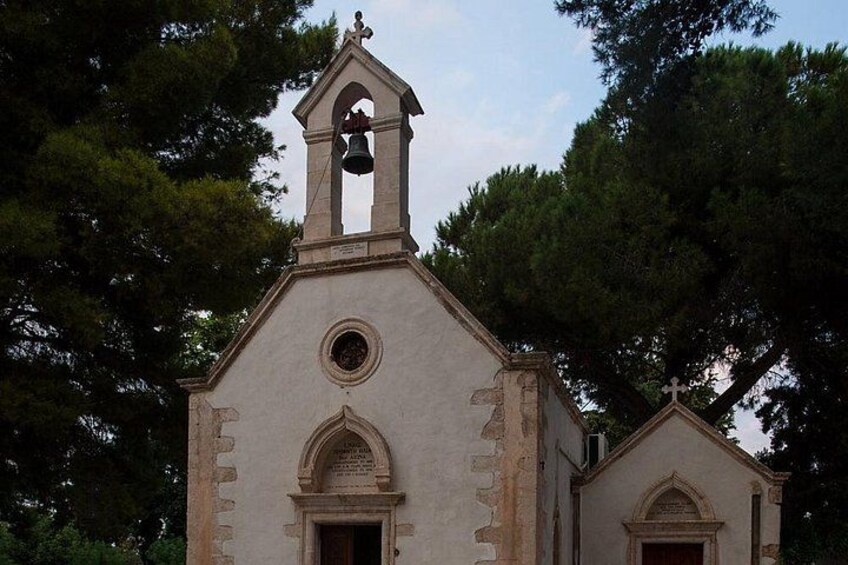A church with a bell tower, arched windows, and a cross on top. 4