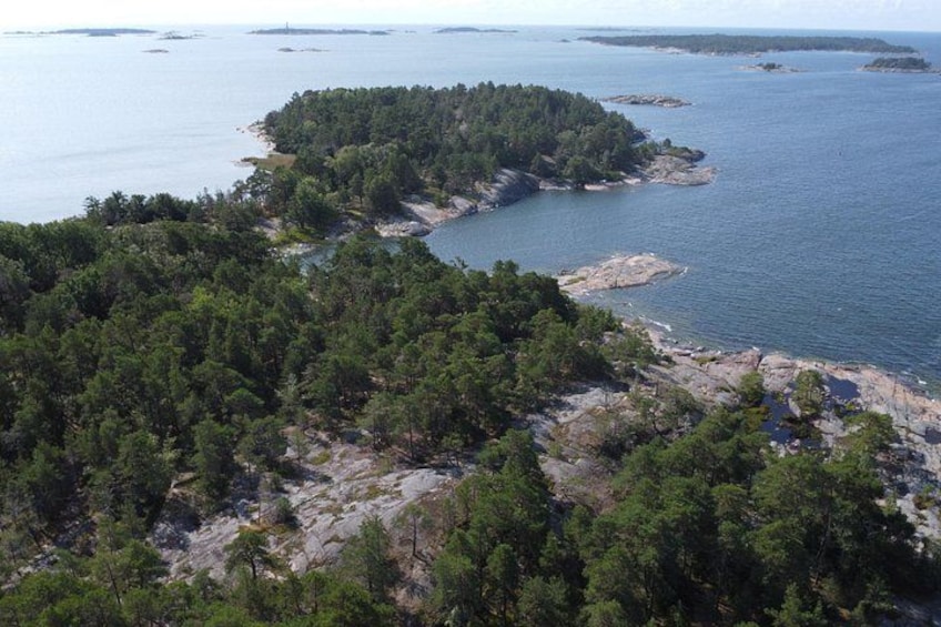 A coastal landscape with dense forests, rocky outcrops, and calm waters. 2