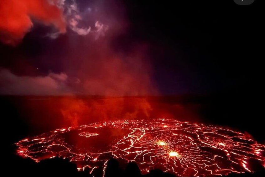 Une scène nocturne où le sol est illuminé d’une lueur rouge, probablement due à des feux d’artifice ou à des jeux de lumière. 1