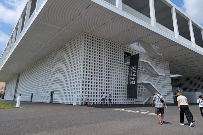 A modern building with a grid-like facade and a prominent black banner. 3