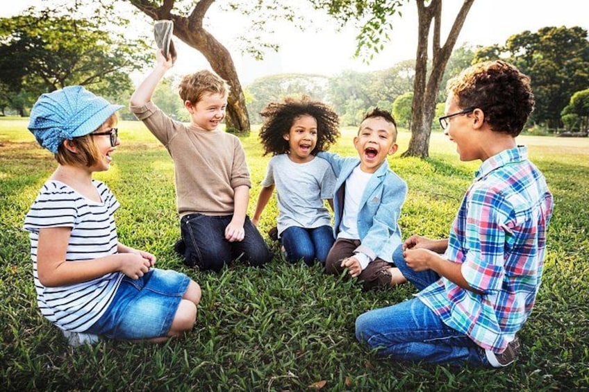 A group of people sitting on grass in a park. 4