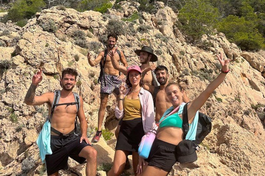 Un grupo de personas caminando por terreno rocoso con montañas al fondo. 2