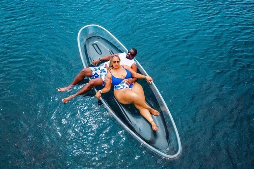 Two people on a small boat in clear blue water. 3