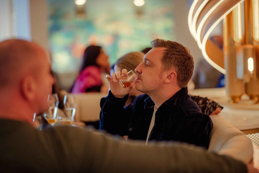 A person drinking from a glass in a restaurant setting. 5
