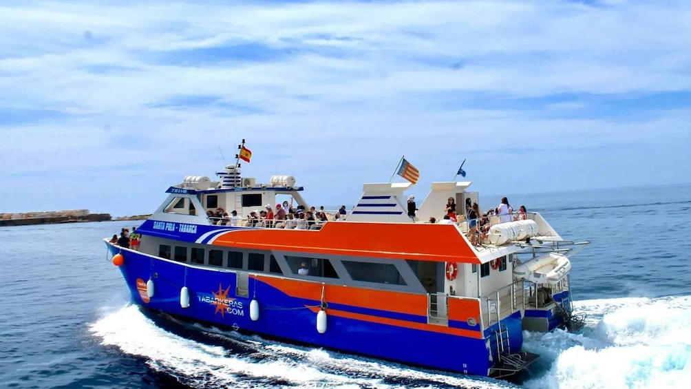 Un barco azul y naranja llamado Santa Pola Tabarca con gente en cubierta, navegando en el mar. 3