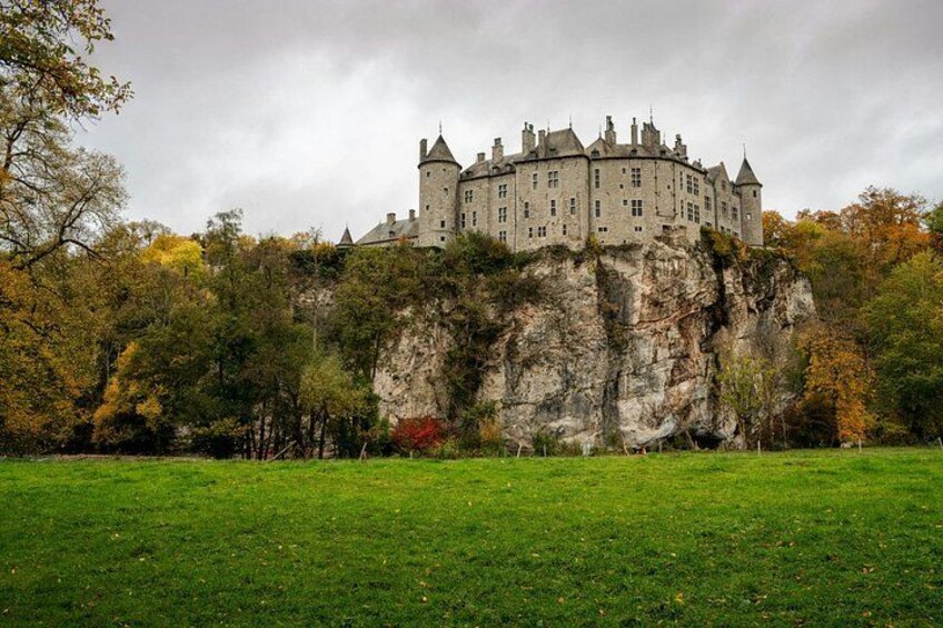 Eine Burg auf einer Klippe mit einer grünen Wiese im Vordergrund. 4