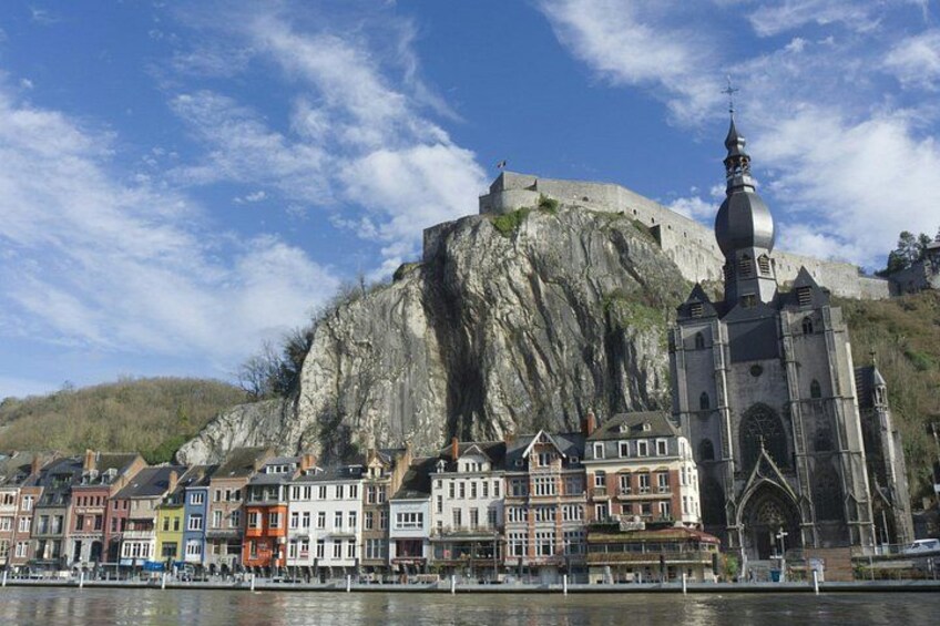 Eine historische Stadt mit bunten Häusern, einer markanten Kirche und einer großen Befestigung auf einem Hügel. 1