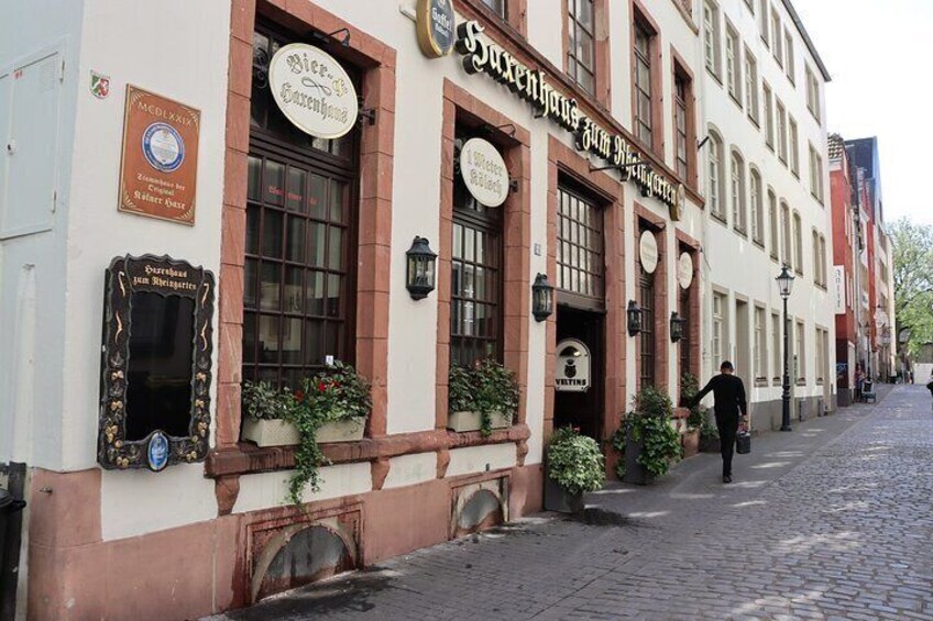 A traditional European building with multiple signs, including one for a beer garden. 5