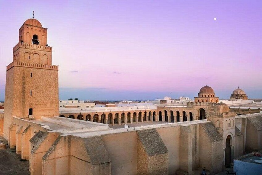 Eine historische Festung mit einem markanten Turm, Kuppelgebäuden und einer Reihe von Bögen. 5