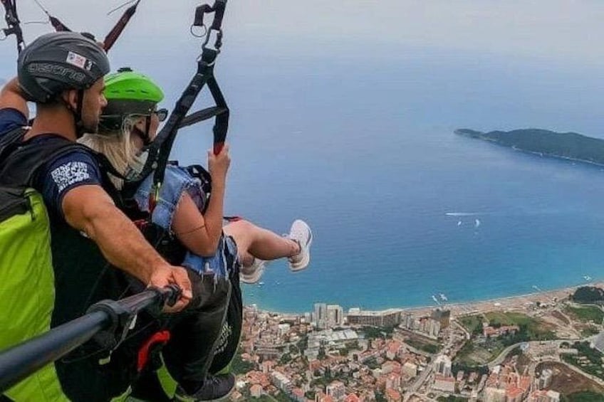 A group of people on a tandem paragliding flight over a coastal city. 4