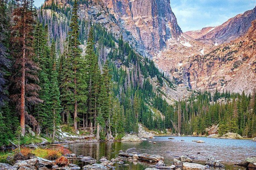 A mountain landscape with a river, dense coniferous forest, and rocky cliffs. 2