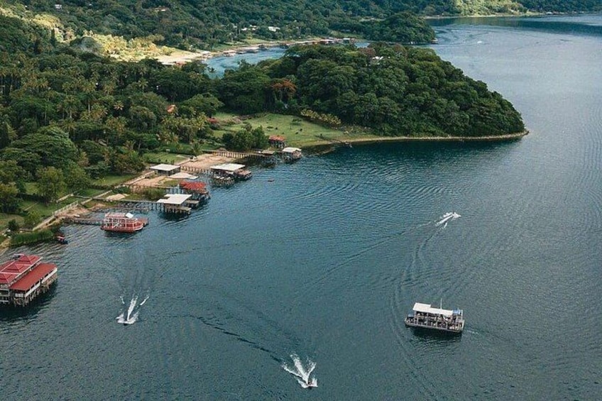 A river with boats, a dock, and a forested island. 3