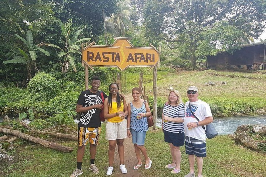 Un grupo de personas de pie frente a un letrero que dice 'RASTA AFARI'. 5