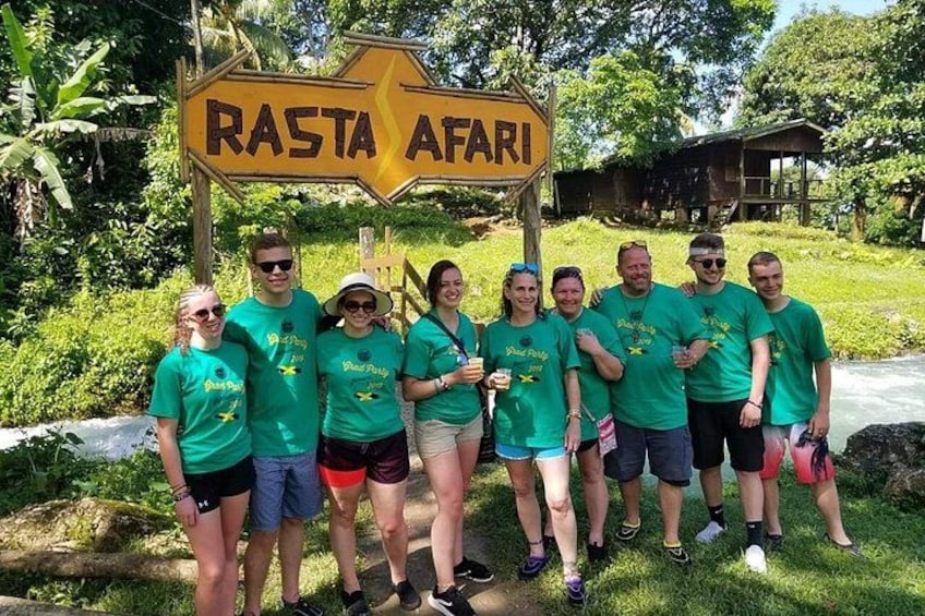 Un grupo de personas con camisetas verdes de pie frente a un letrero que dice 'RASTA AFARI'. 4