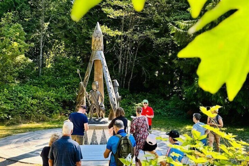 A group of people gathered around a large, ornate sculpture in a park. 3