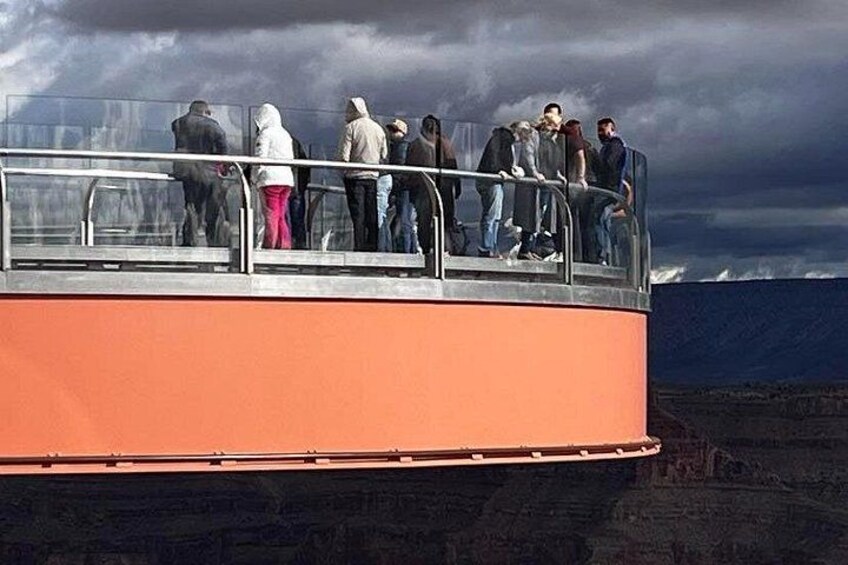 A group of people on a glass-bottomed boat with a rocky landscape in the background. 3