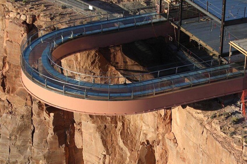 A curved glass bridge over a canyon. 2