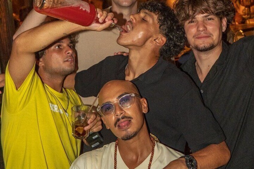 A group of people at a social event, some holding drinks. 1