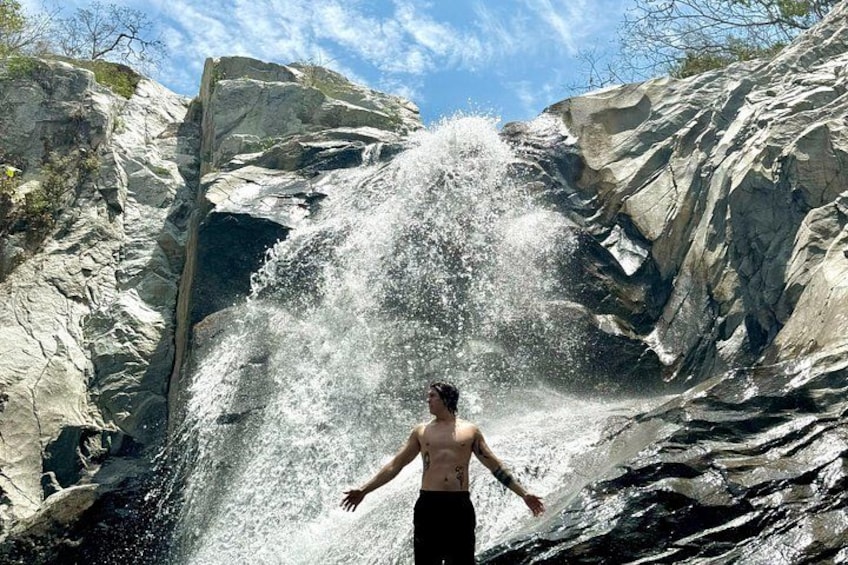 Een waterval met iemand die ervoor staat. 2